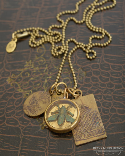 Stamped clay pendant with brass bird etched charm